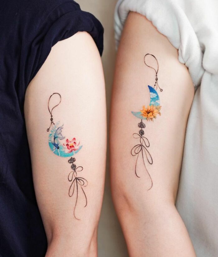Matching best friend tattoos featuring colorful floral designs on arms.
