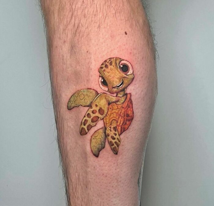 Cartoon tattoo of a cute turtle Squirt on a person's leg, showcasing a nostalgic design with vibrant colors.