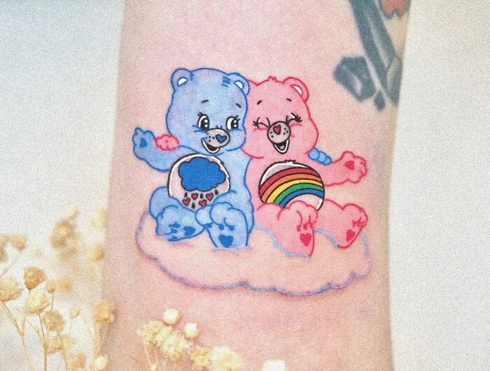 Cartoon tattoo with two colorful Care bears sitting on a cloud, evoking nostalgia.