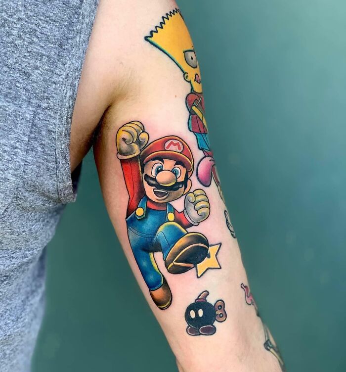 Video game tattoos featuring Mario character on an arm, showcasing vibrant colors and detailed design.