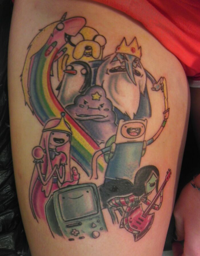 Colorful cartoon tattoo featuring nostalgic characters from Adventure Time in a vibrant design.