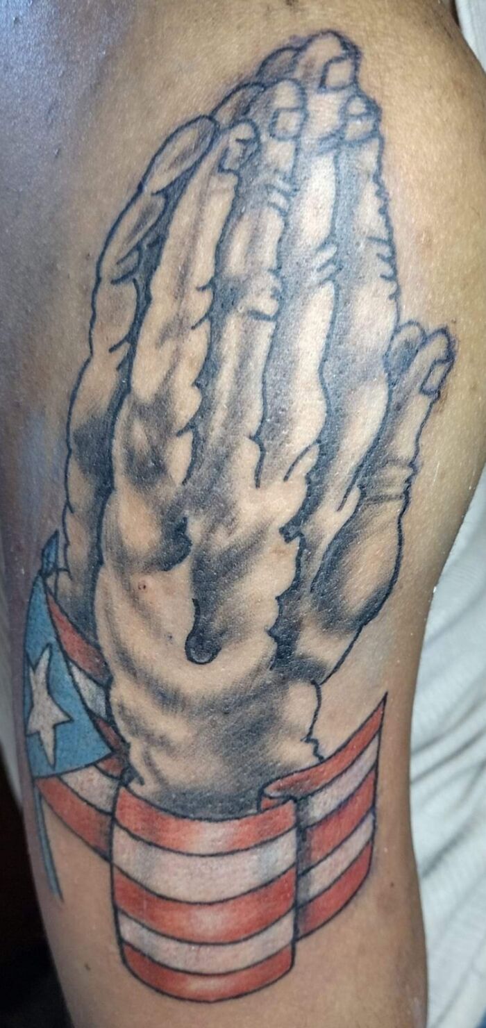 Tattoo of praying skeletal hands wrapped in an American flag, highlighting poor research on tattoo artist choice.