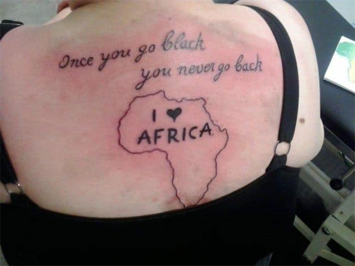 Back tattoo of Africa outline with text, showcasing a permanent mistake.
