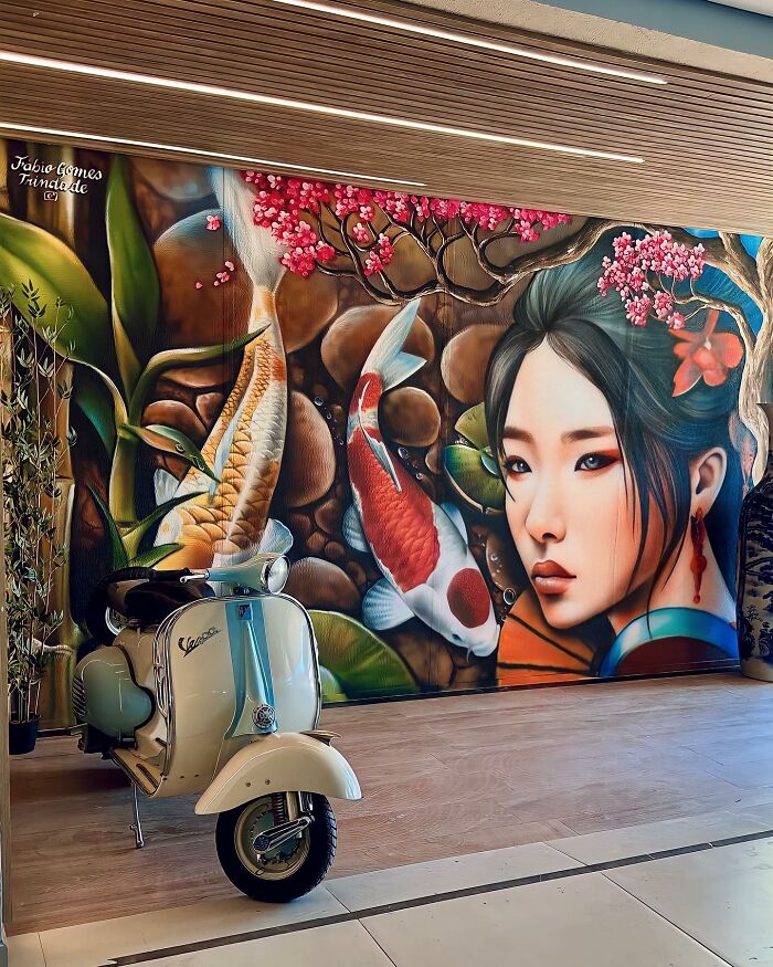 Street Artist Continues To Paint Portraits On Walls Next To Trees That Double As Hair