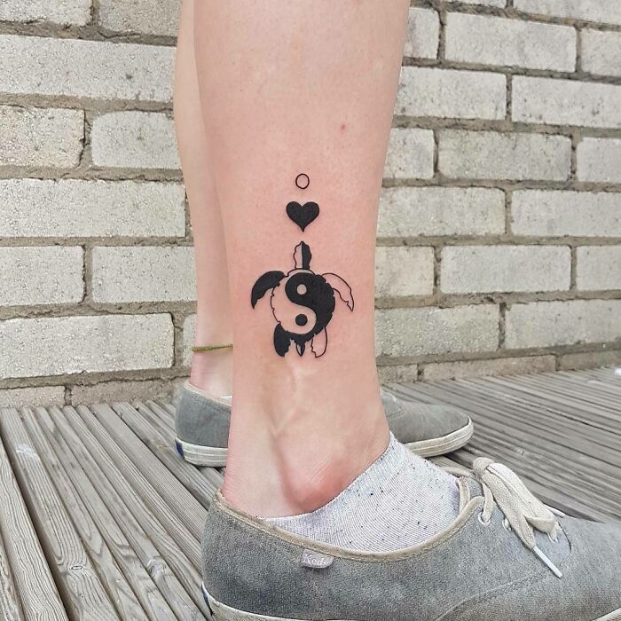 Yin Yang tattoo featuring a turtle design on a person’s calf, symbolizing life duality.