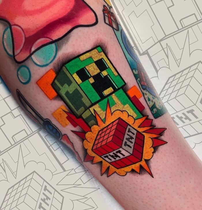 Colorful Minecraft video game tattoo with a pixelated character and TNT block on an arm.