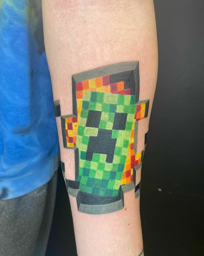 Pixelated Creeper tattoo from Minecraft on forearm, showcasing vibrant video game art for dedicated gamers.