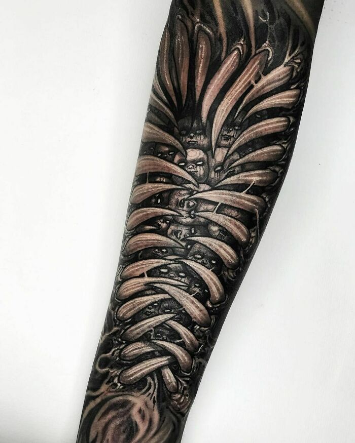 Intricate gothic tattoo design with abstract elements on a forearm.