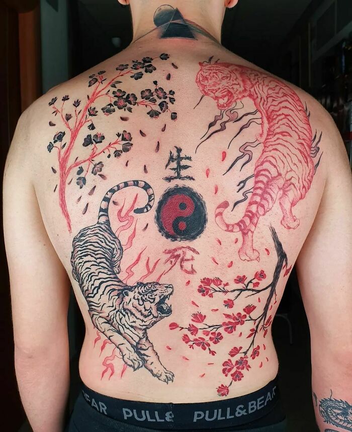 Back tattoo featuring a Yin Yang symbol with red and black tigers and cherry blossoms.