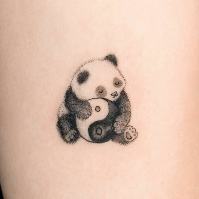 Panda holding a yin yang tattoo, symbolizing the duality of life.