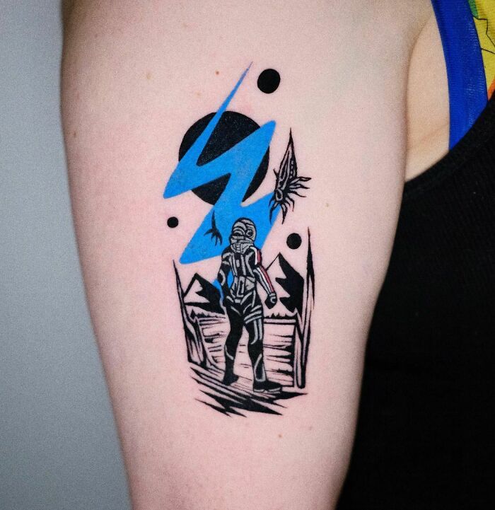 Video game tattoo featuring a futuristic warrior in blue and black on the arm of a gamer.