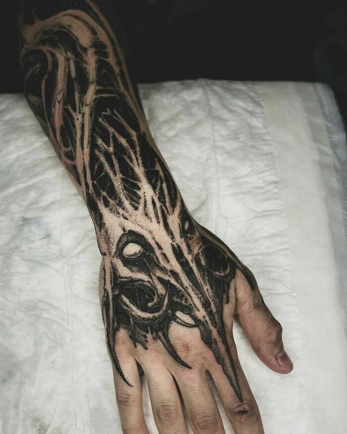 Intricate gothic tattoo design covering a hand, showcasing dark and detailed artwork.