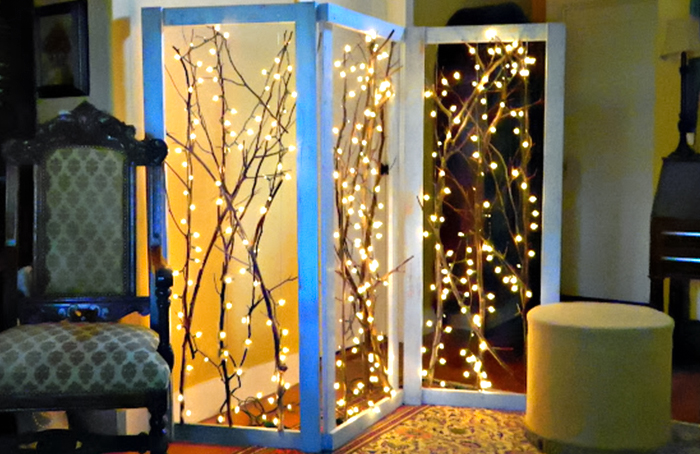 DIY room divider consisting of three wooden white painted frames with tree branches and warm fairy lights inside of them DIY room divider consisting of three wooden white painted frames with tree branches and warm fairy lights inside of them