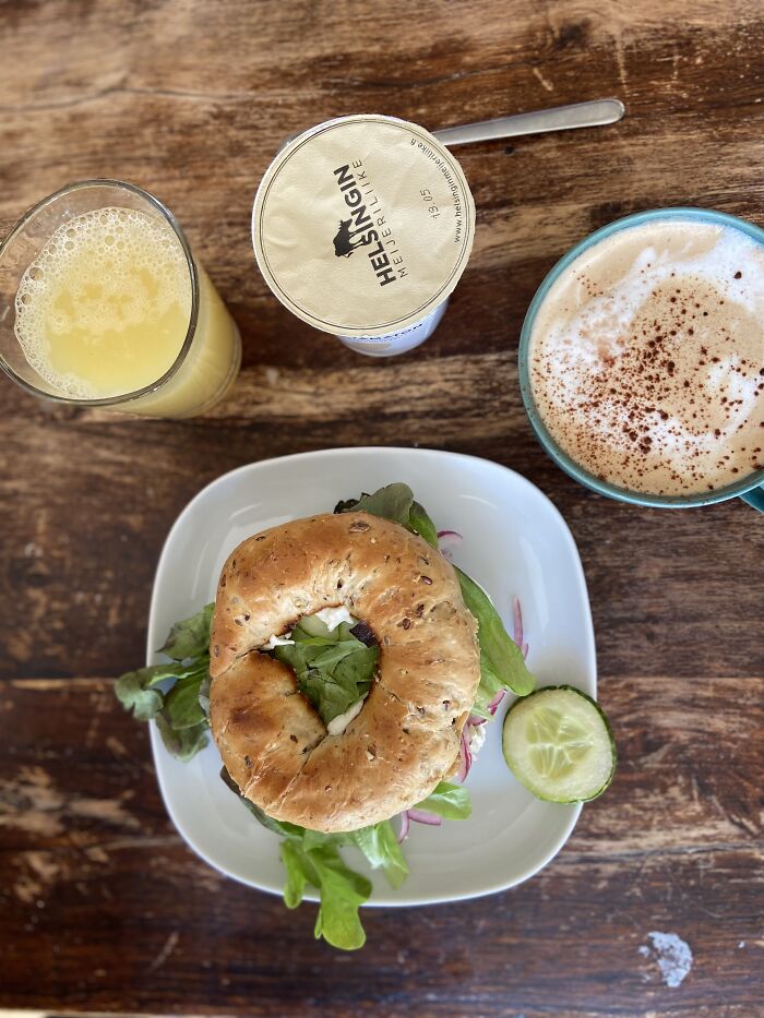 Apple Juice, Natural Yoghurt, Cappuccino And Toasted Bagel Filled With Boiled Egg, Cream Cheese And Greens, And Of Course Home Made Marinated Red Onion