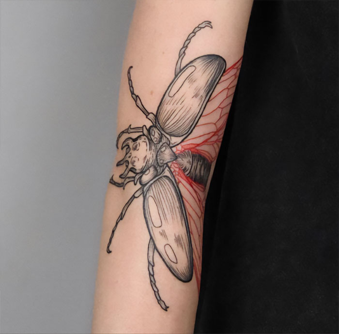 Stylish insect elbow tattoo design showcasing intricate linework and shading.