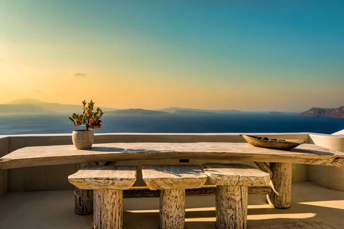 A wooden bench and chairs overlooking the sky and mountains A wooden bench and chairs overlooking the sky and mountains