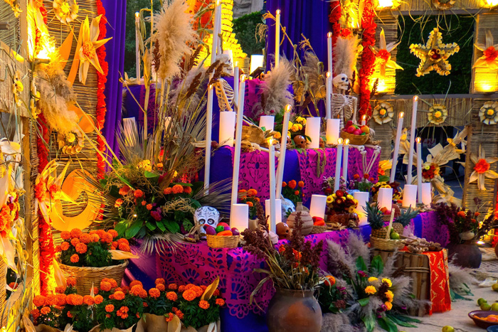 Colorful Day of the Dead altar in Mexico with marigolds, candles, skulls, and traditional decorations celebrating cultural diversity.