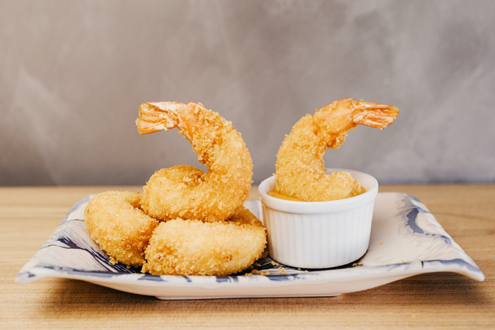 Tempura shrimp served on a ceramic plate with dipping sauce, showcasing culture facts about global food diversity.