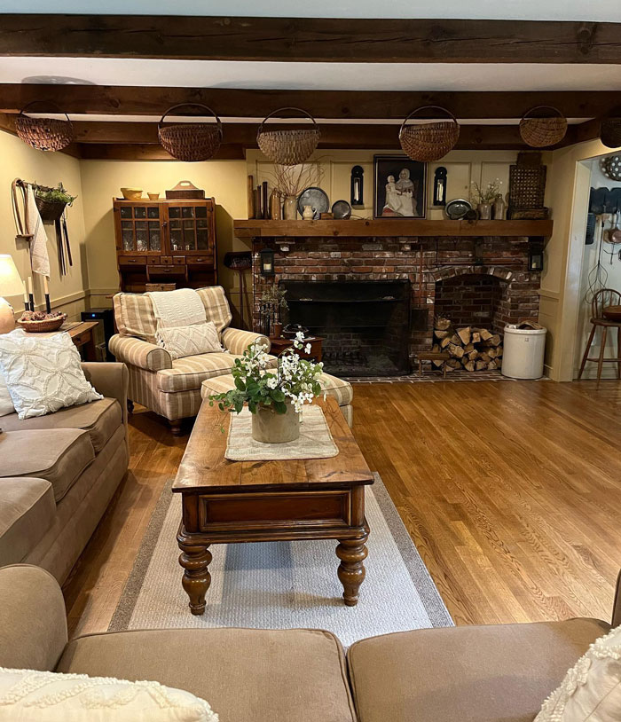 Brick and wood based farmhouse room with sofas wooden table and baskets Brick and wood based farmhouse room with sofas wooden table and baskets