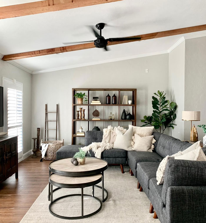 Living room with dark gray sofa white rug wooden table and cupboards Living room with dark gray sofa white rug wooden table and cupboards