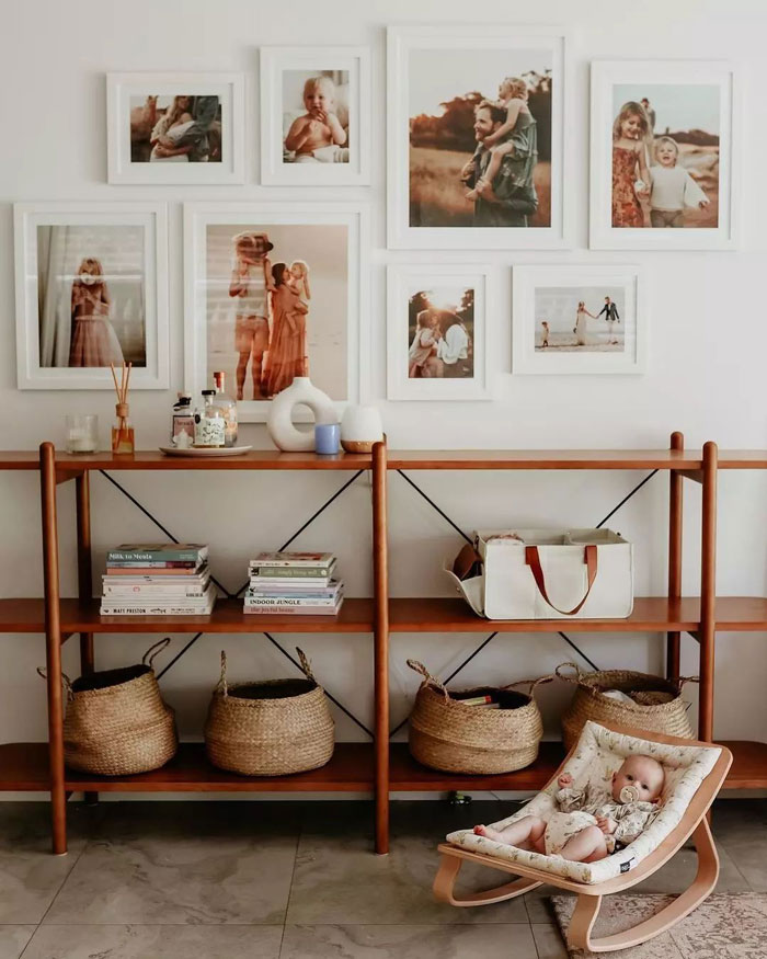 Brown cupboard with books and baskets and baby resting in bed Brown cupboard with books and baskets and baby resting in bed