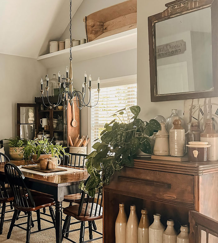 Farmhouse old table with old cabinet with bottles and flowers Farmhouse old table with old cabinet with bottles and flowers