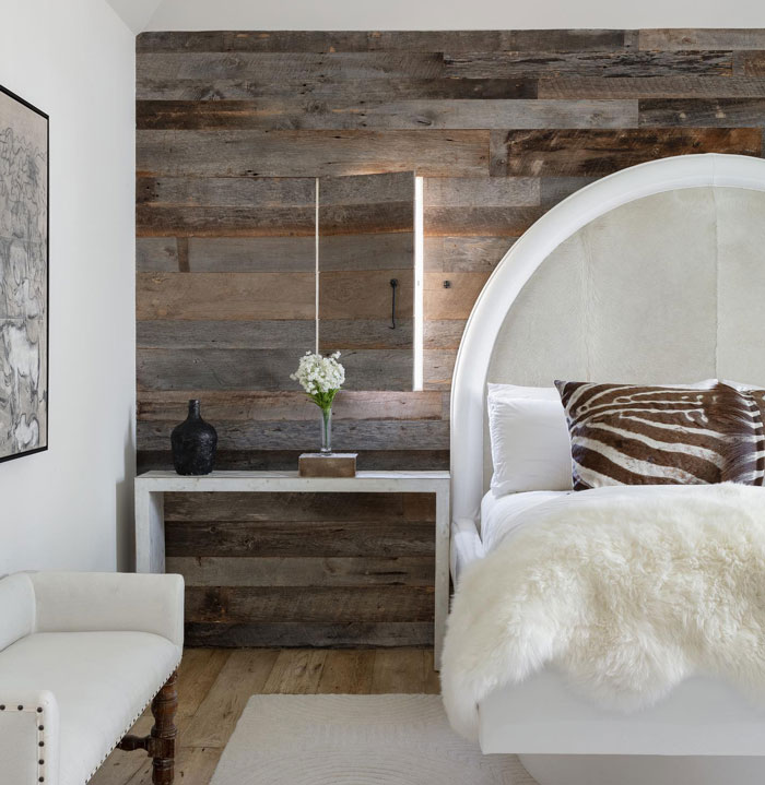 Room with wooden wallpaper and bed with white sheets and brown stripped pillows Room with wooden wallpaper and bed with white sheets and brown stripped pillows