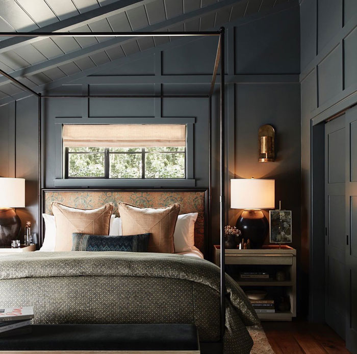 Black room with bed with gray sheets brown pillows and cupboard with lamps Black room with bed with gray sheets brown pillows and cupboard with lamps