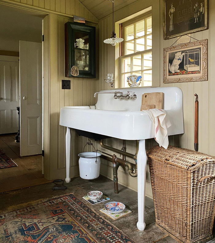 Vintage rug with white sink basket and portraits on the wall Vintage rug with white sink basket and portraits on the wall