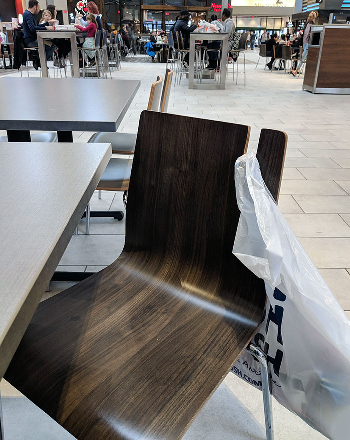 Chairs In A Mall Food Court Are Notched To Hold Shopping Bags