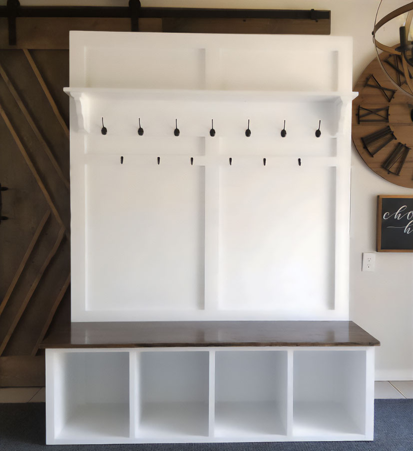 A white hall tree with hooks and a brown shoe storage bench A white hall tree with hooks and a brown shoe storage bench