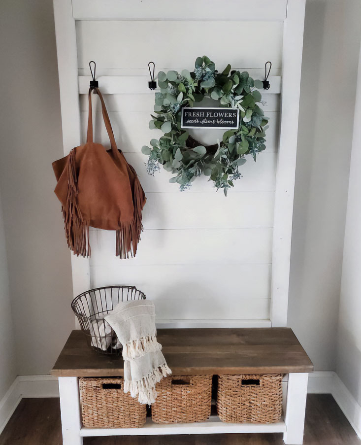 A white hall tree with a bag, wreath, and basket on it A white hall tree with a bag, wreath, and basket on it