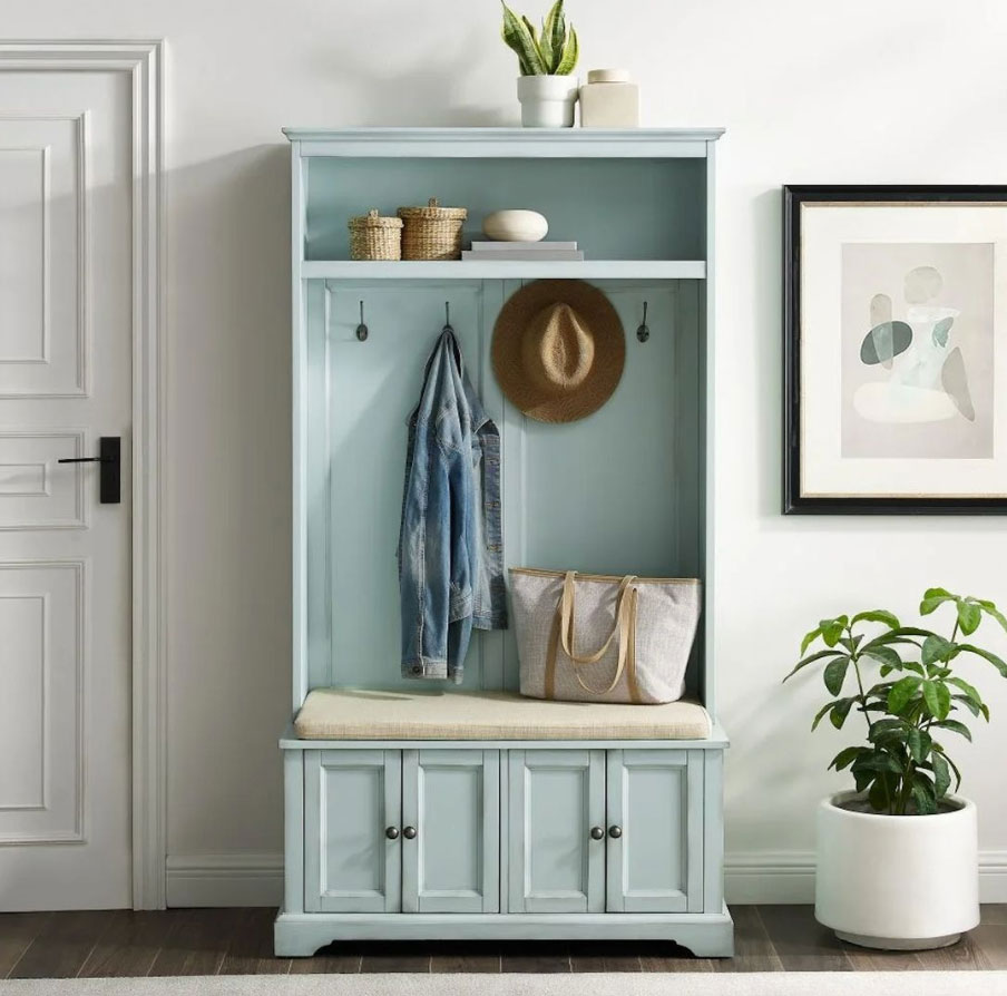A blue-painted narrow hall tree with jacket, basket and hat on it A blue-painted narrow hall tree with jacket, basket and hat on it