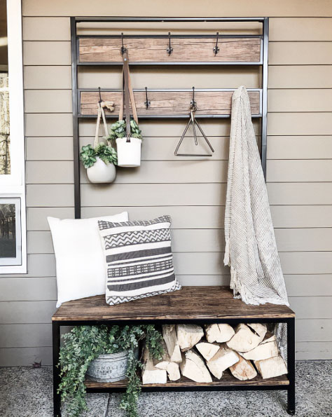 A wood and metal hall tree with pillows and firewood on it A wood and metal hall tree with pillows and firewood on it