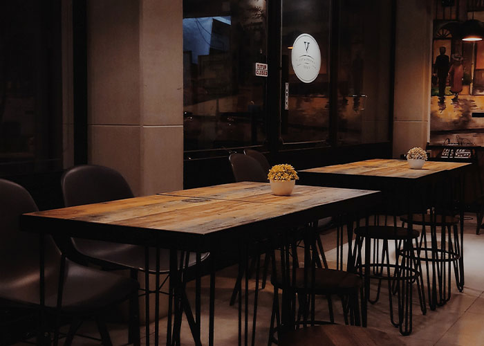 Cozy restaurant interior with wooden tables and green flags indicating a place you should definitely eat there.