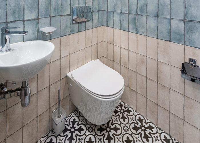 Clean and well-maintained restaurant bathroom with patterned tile floor indicating restaurant green flags for quality hygiene.