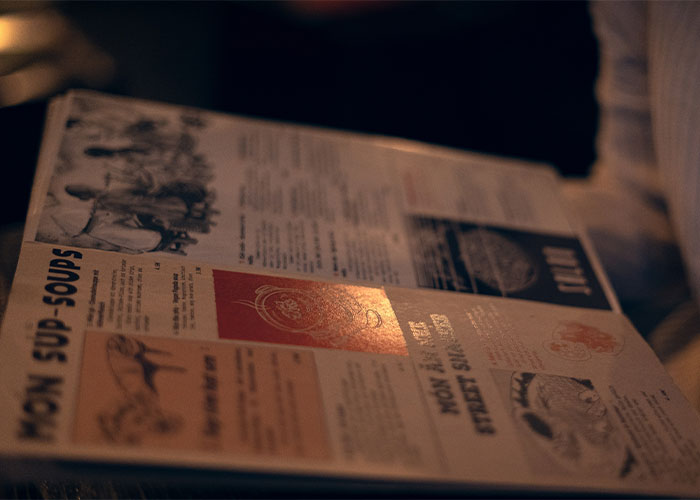 Close-up of a vintage restaurant menu showing soups and street snacks, highlighting restaurant green flags to eat there.