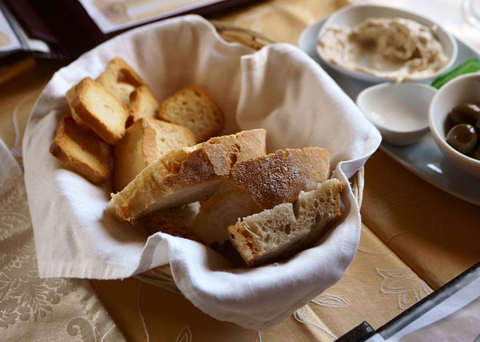 Basket of fresh bread and crackers on a table, highlighting restaurant green flags for great dining experiences.
