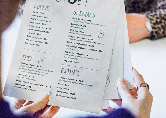 Person holding a restaurant menu, highlighting green flags that indicate you should definitely eat there.