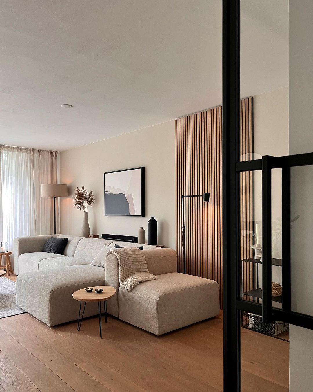 Modern beige living room featuring a large couch, wooden accents, and minimalist living room ideas for interior refresh.