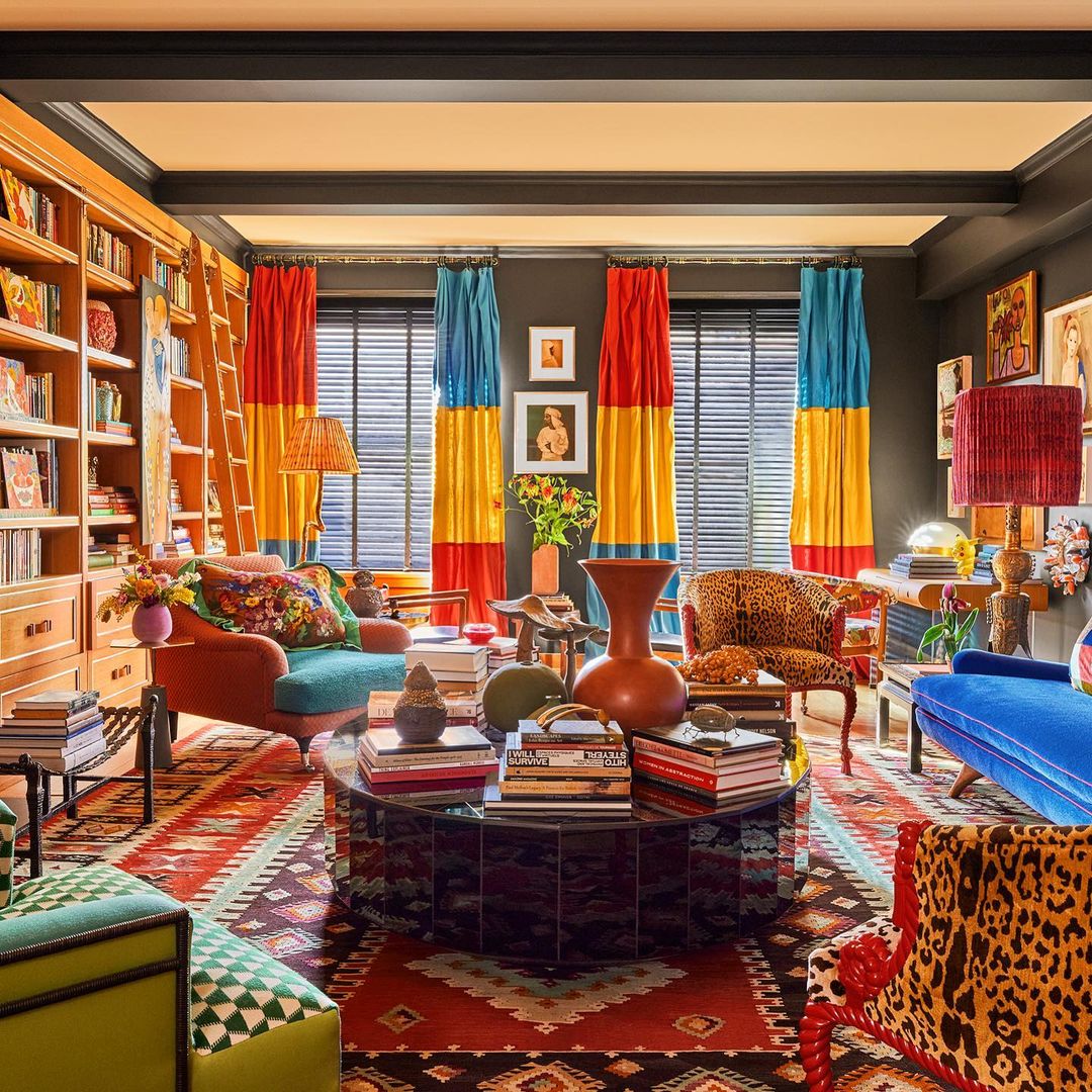 Maximalist colorful living room with round coffee table, vibrant curtains, patterned rugs, and eclectic furniture for interior ideas.