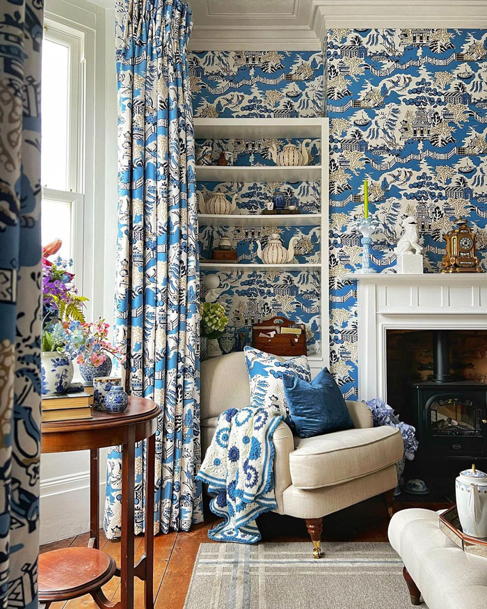 Living room with blue patterned wallpaper and curtains featuring interior ideas and designer insights.