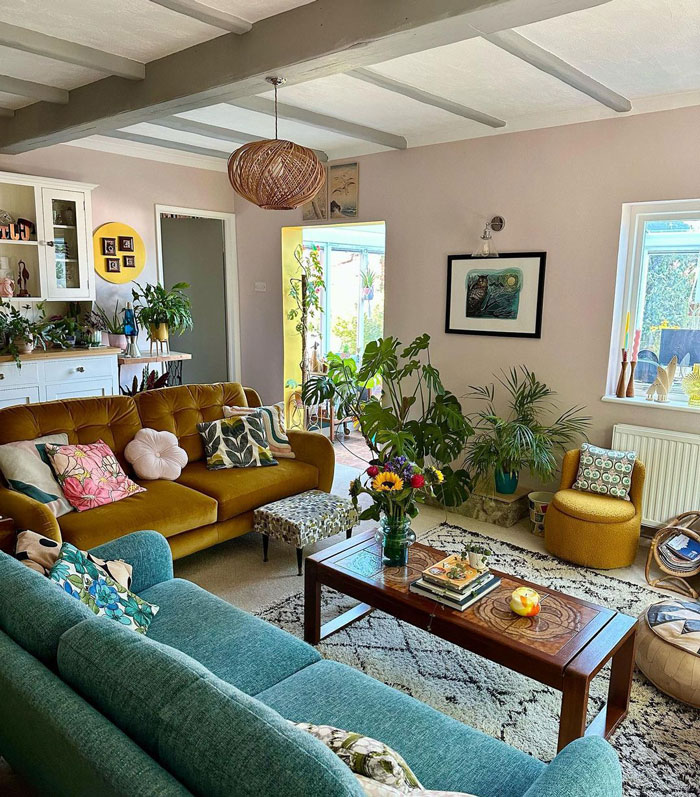 Living room ideas featuring blue and yellow couches, a coffee table, and abundant plants for refreshing interior decor.