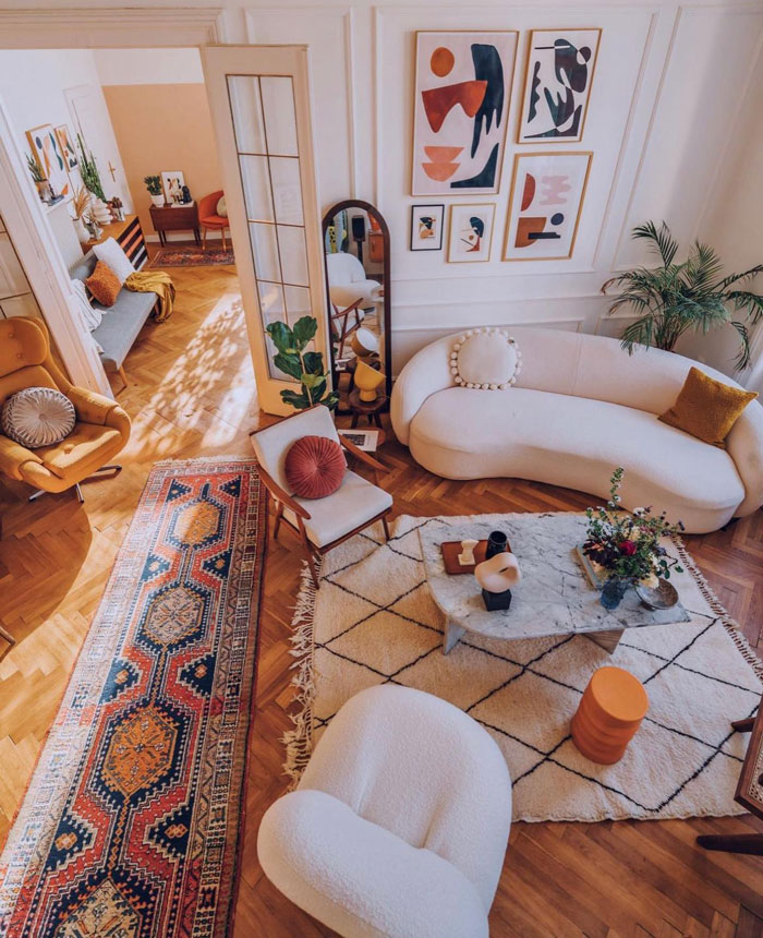 Living room ideas featuring a white couch, armchairs, graphic wall art, and stylish coffee table in a bright living space.