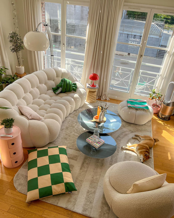 Cozy living room with white couch, large windows, modern furniture, and natural light for living room ideas and designer insights.