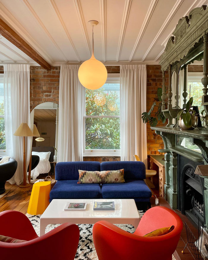 Cozy living room ideas with a blue couch, red armchairs, fireplace, and stylish interior design insights.