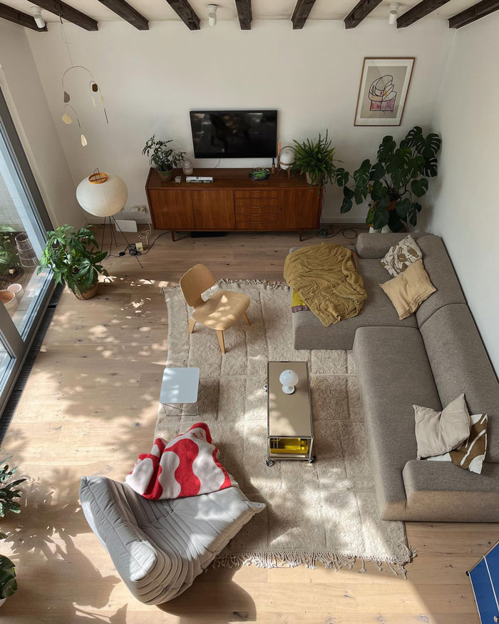 Living room ideas featuring a gray couch, white walls, wooden floor, and abundant plants for interior refresh.