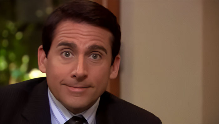 Michael Scott smiling in a suit and tie, showcasing the best boss ever vibe from popular Michael Scott quotes.