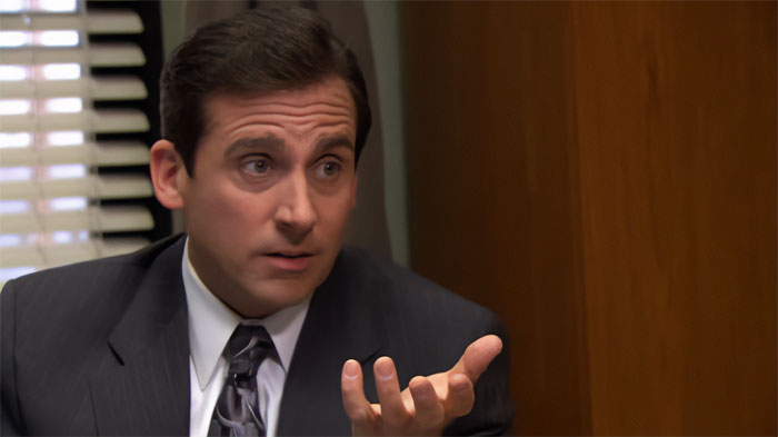 Michael Scott talking in a suit and tie, demonstrating his best boss qualities in an office setting.