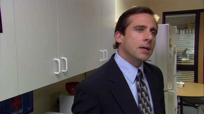 Michael Scott speaking in office kitchen, illustrating memorable quotes from the best boss ever in a workplace setting.